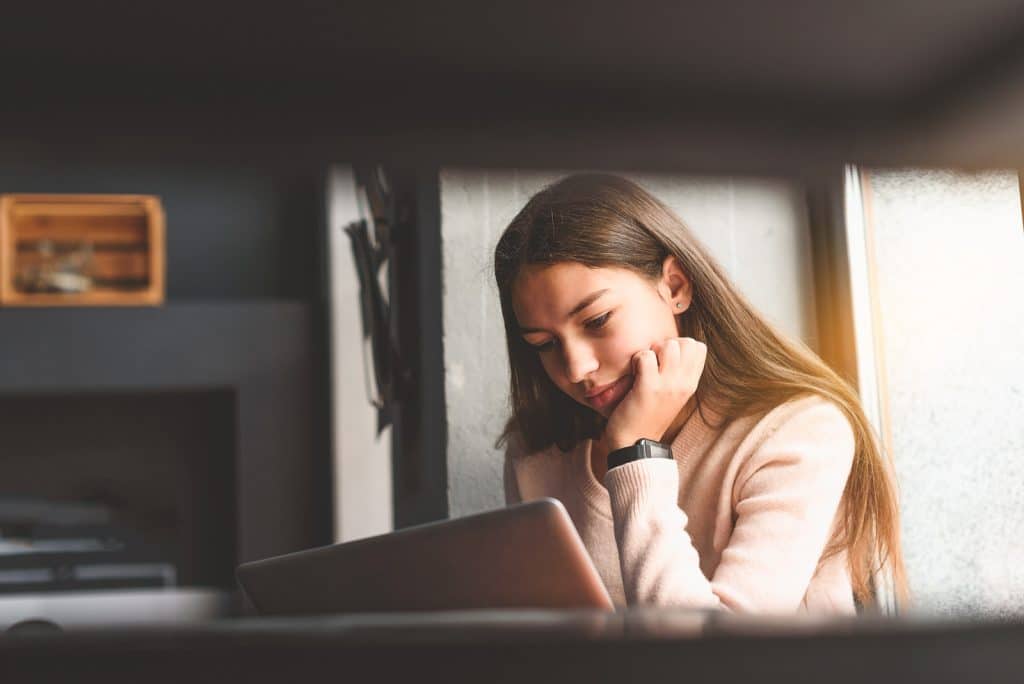 Pensive pupil looking at her laptop