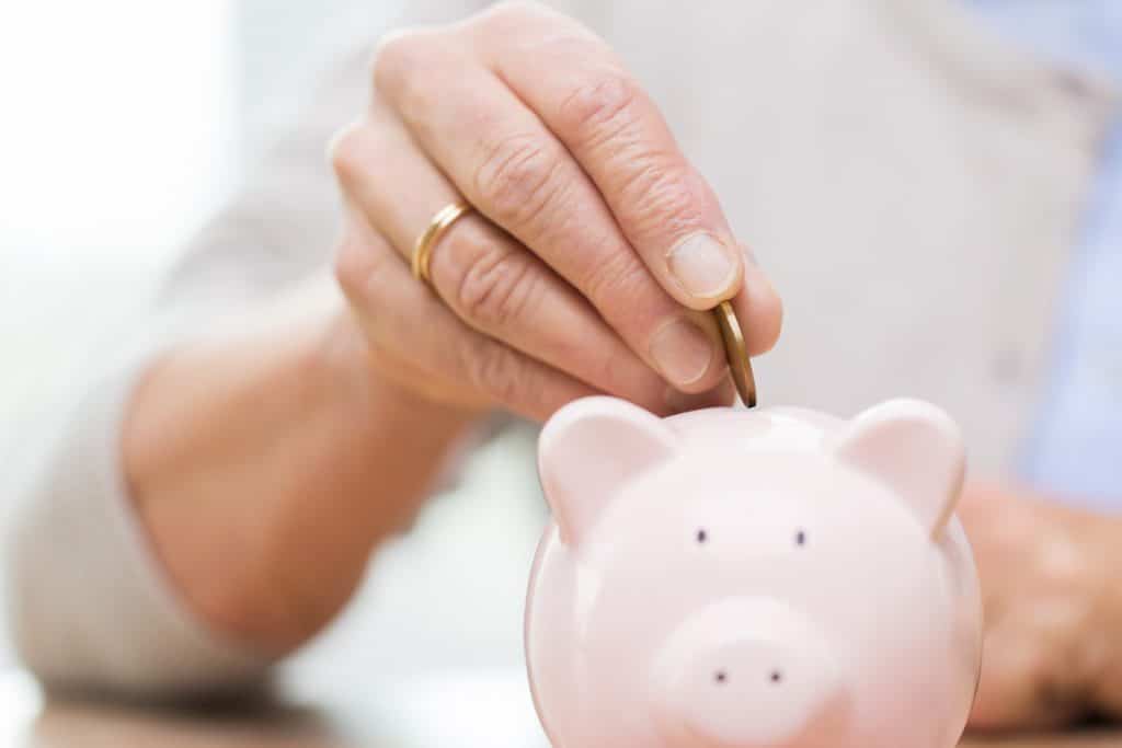 A coin being put into a piggy bank
