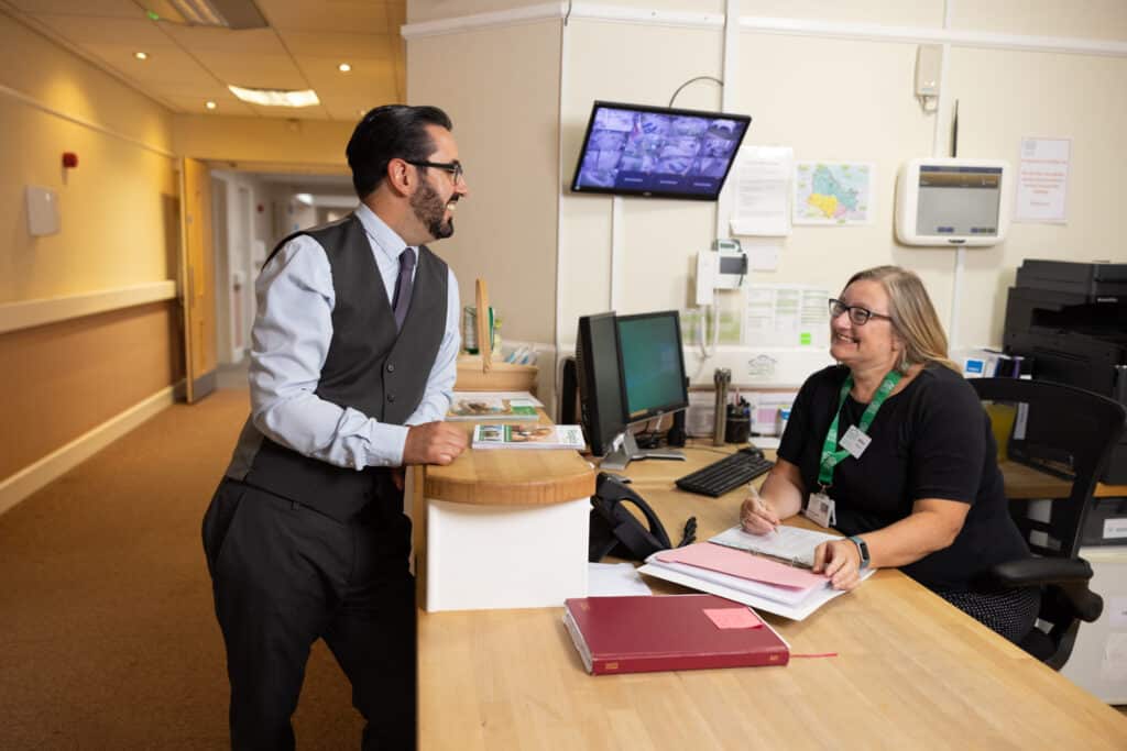 Chief Exec with female volunteer at desk