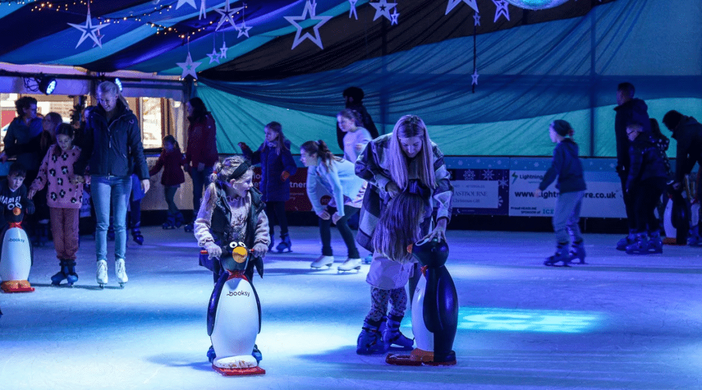Woman and kids ice skating with penguin skates