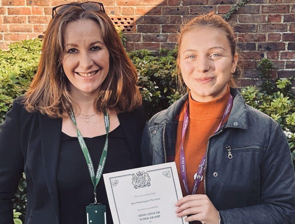 female student with head teacher and army scholarship certificate