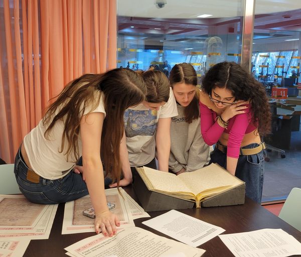 group of young women looking at large books