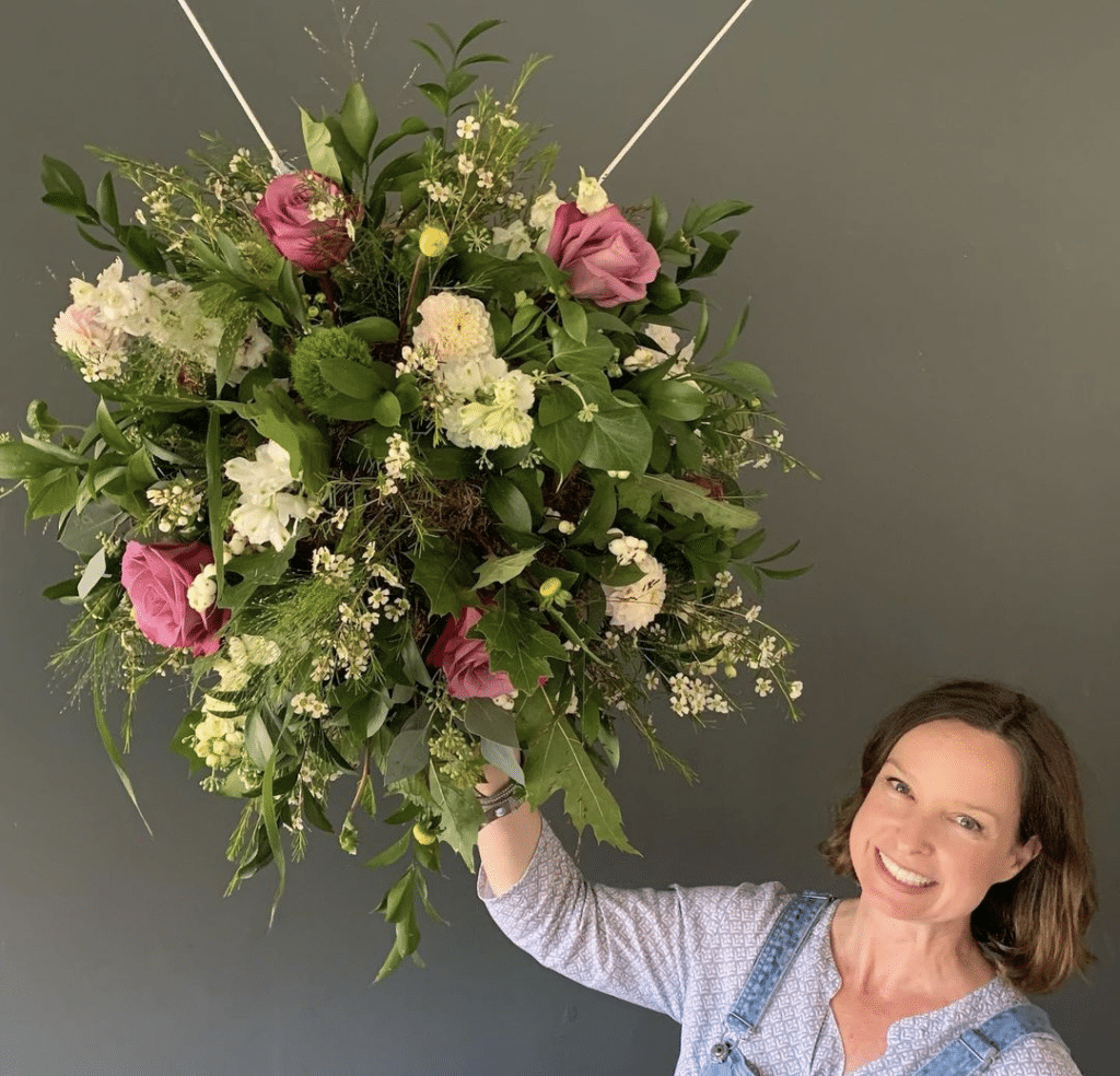 woman holding up bunch of flowers