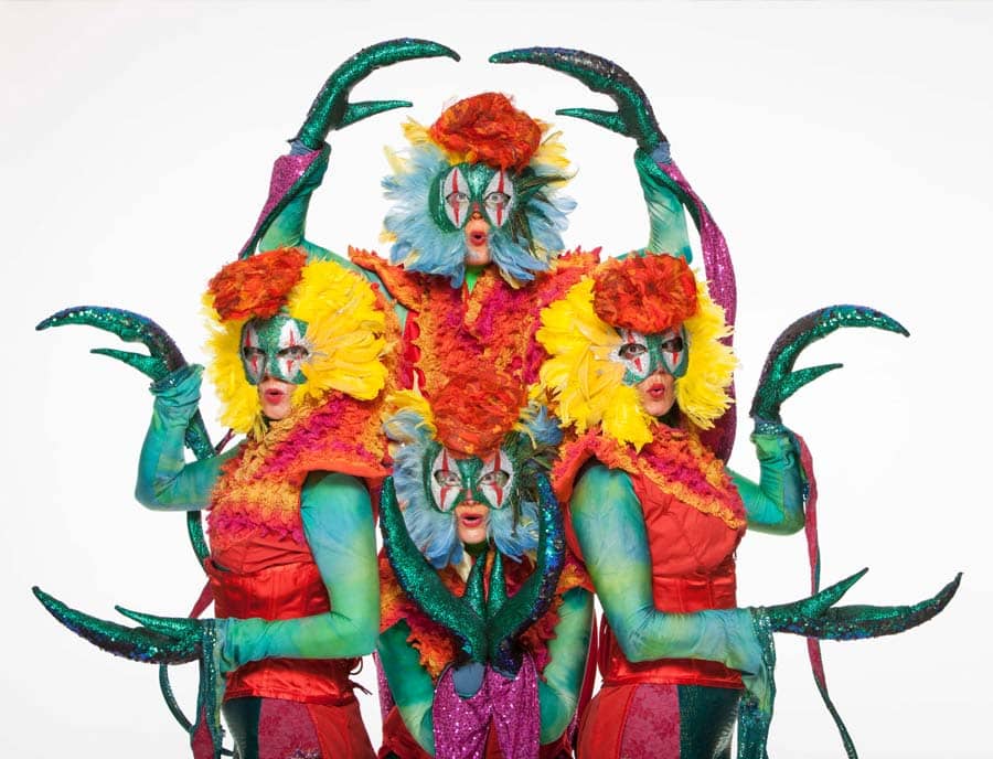 green and brightly coloured dragon costume performers