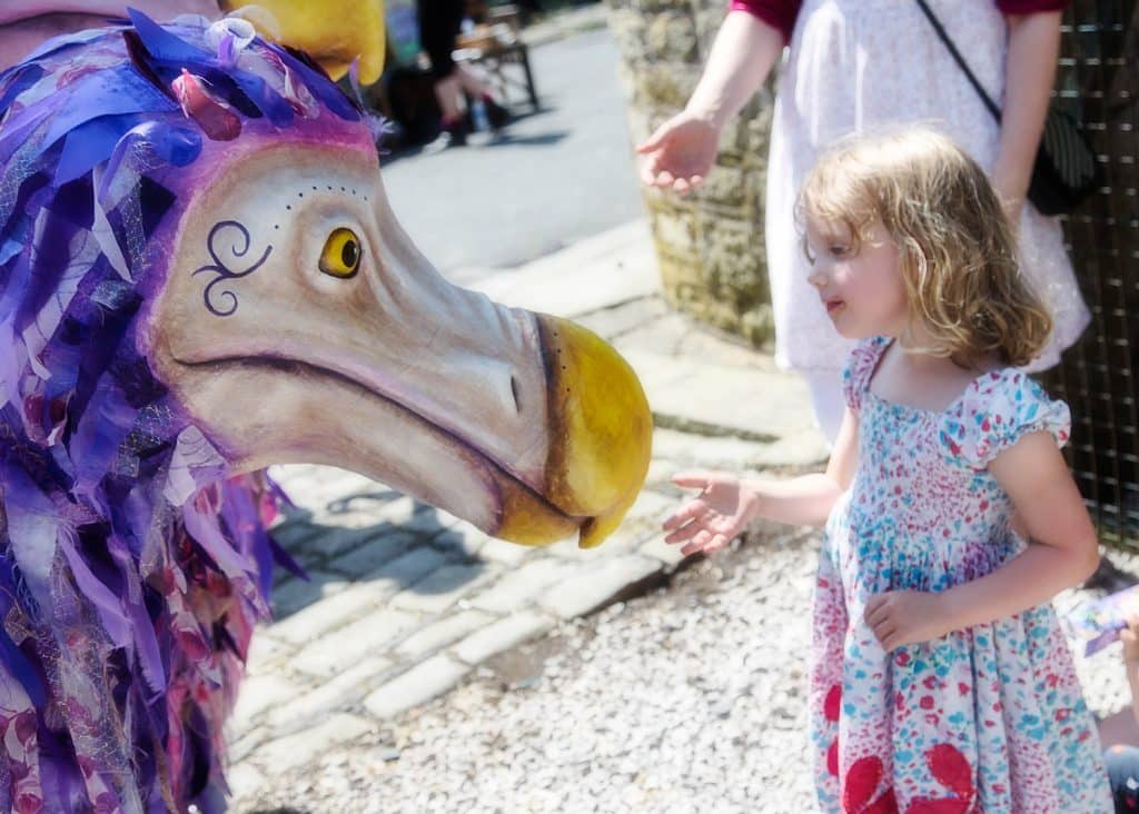 Purple patterned dodo costume character with little girl