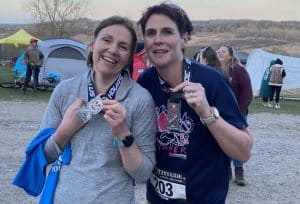 two female runners after a race with medals